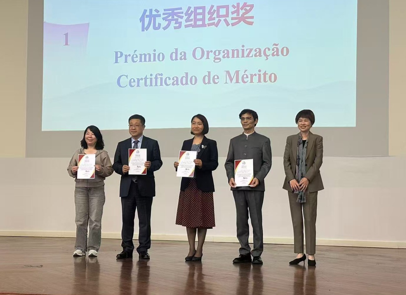 A diretora chinesa do ICUM, Zhang Yan (ao centro) a receber o certificado de mérito
